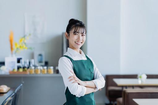 カフェで働く若い女性 カフェで働く若い女性の写真