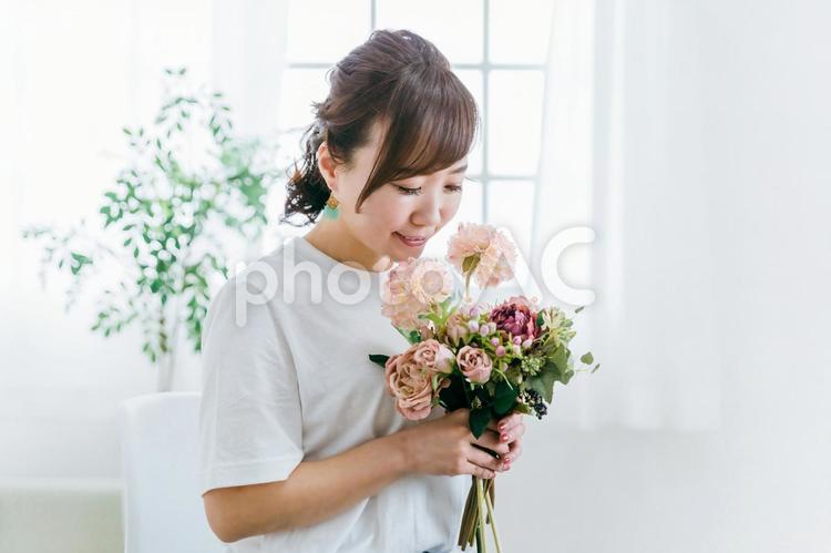 贈り物の花束の匂いを嗅ぐ日本人女性 花,フローラル,アロマの写真素材
