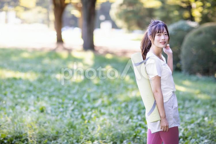 ヨガマットを持ってカメラ目線の女性 女性,ヨガマット,持つの写真素材