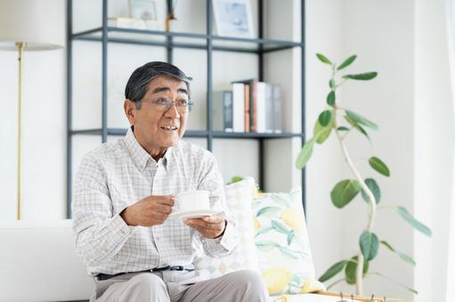 リビングでコーヒーを飲むシニアの男性 リビングでコーヒーを飲むシニアの男性 シニア,コーヒー,男性の写真素材