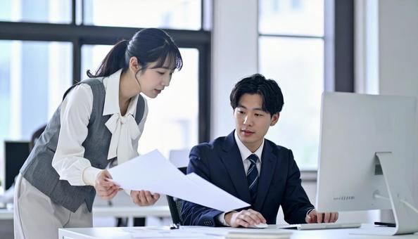 上司に資料を確認する女性社員 上司に資料を確認する女性社員の写真