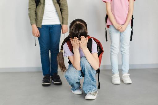 しゃがんで泣いている女の子と立っている子どもたち 女の子,リュック,泣くの写真素材