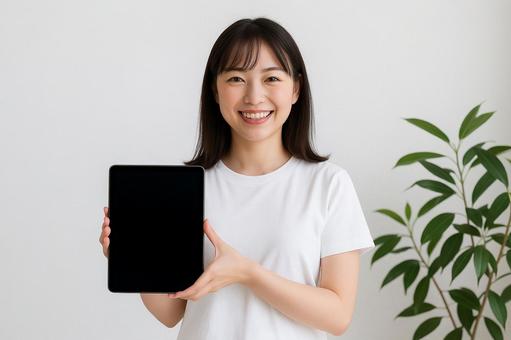 タブレットを見せる女性 タブレットを見せる女性の写真