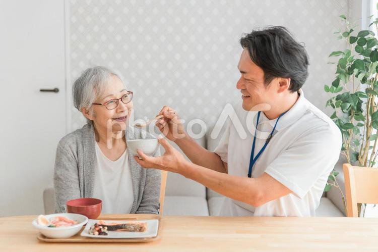 食事介助する男性スタッフ 食事介助,介護食,高齢者の写真素材