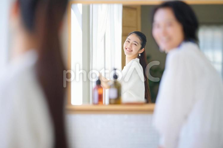 鏡越しの若い女性と振り向く中年女性 女性,人物,振り向くの写真素材