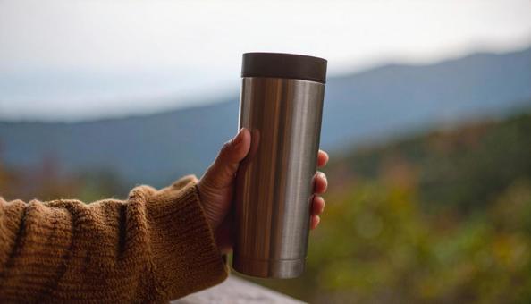 タンブラーを持つ女性の手の写真