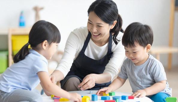 保育園で子供と遊ぶ笑顔の保育士の女性 保育園で子供と遊ぶ笑顔の保育士の女性の写真