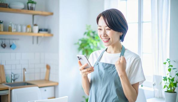 スマホでポイ活する笑顔の女性 スマホでポイ活する笑顔の女性の写真