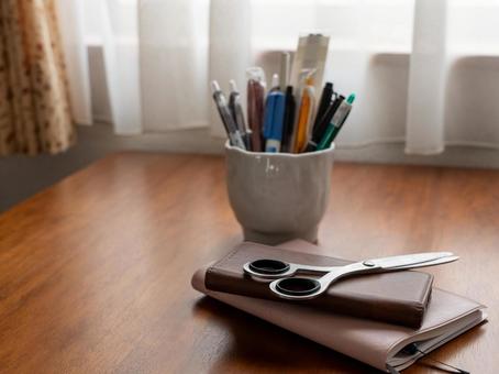 机の上のはさみとノートとペン立て はさみ,携帯電話,手帳の写真素材