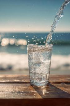 ビーチで楽しむ冷たい一杯の水の写真