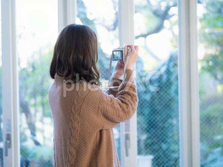 22：カメラを構える女性 カメラ,データチェック,カメラマンの写真素材