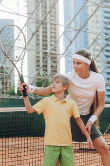 屋外コートでの親子テニスレッスン 男の子,女性,外国人の写真素材