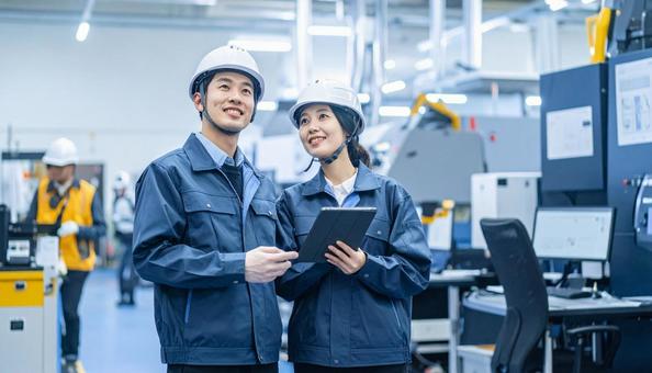 工場でタブレットで製品を検査する作業員 工場でタブレットで製品を検査する作業員の写真