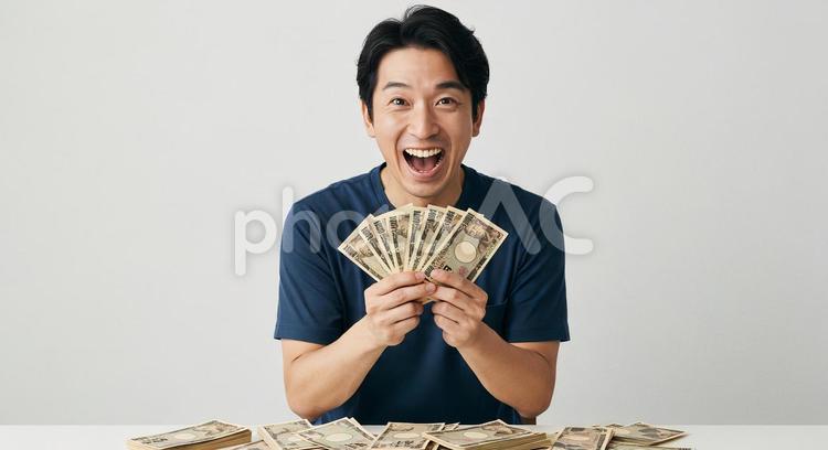 大金を手にして喜ぶ男性 男性,男の人,大金の写真素材