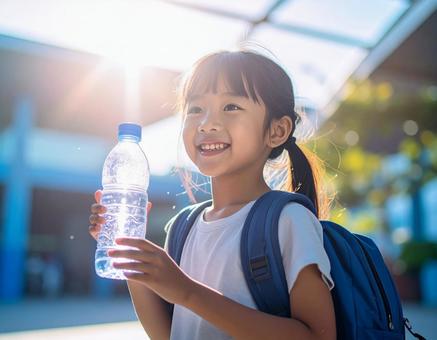 猛暑に水分補給をする女の子の写真
