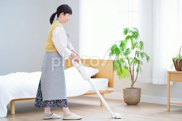 明るい室内で丁寧に掃除をする女性 家政婦,主婦,シニアの写真素材