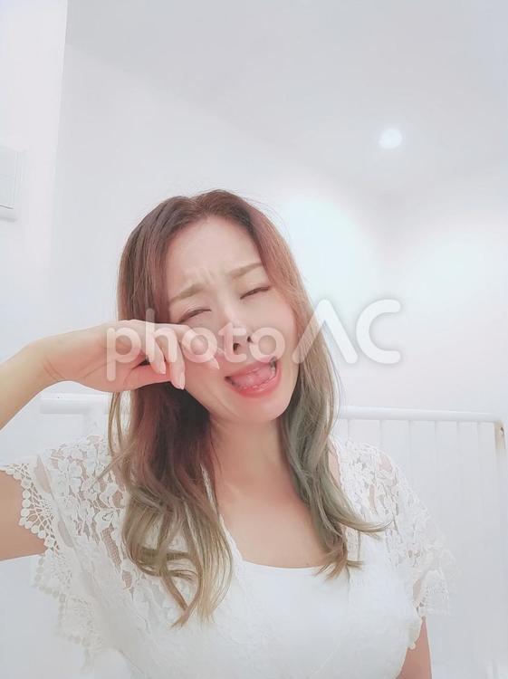 泣きべそをかくロングヘアの女性 泣く,女性,白の写真素材