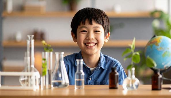 実験している6歳くらいの笑顔の子ども 実験している6歳くらいの笑顔の子どもの写真