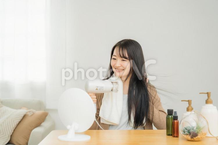 ドライヤーを使う女性 ドライヤー,ヘアードライヤー,髪の毛の写真素材