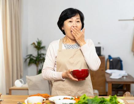 思わず口元を押さえる主婦の驚き 思わず口元を押さえる主婦の驚きの写真