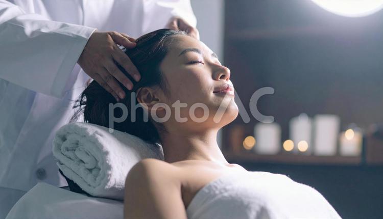 エステサロンでマッサージを受ける女性 ヘッドスパ,ボディマッサージ,サロンの写真素材