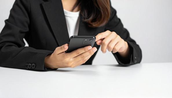 携帯を操作する女性の手元 携帯を操作する女性の手元の写真