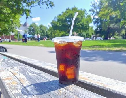 公園のベンチのテイクアウトアイスコーヒー 公園のベンチのテイクアウトアイスコーヒーの写真
