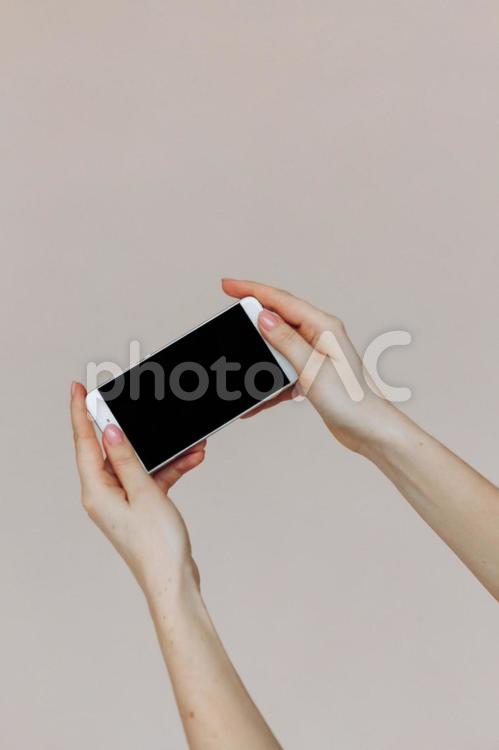 携帯を横にして持つ人の手元 手元,人物,携帯の写真素材