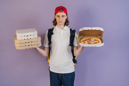 両手にピザの箱を持っている男性（紫背景） 配達,フードデリバリー,デリバリーの写真素材