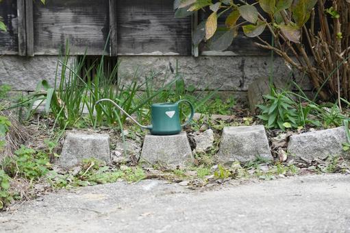 花壇枠の石の上に置かれた園芸用のジョウロ ジョウロ,じょうろ,花壇の写真素材