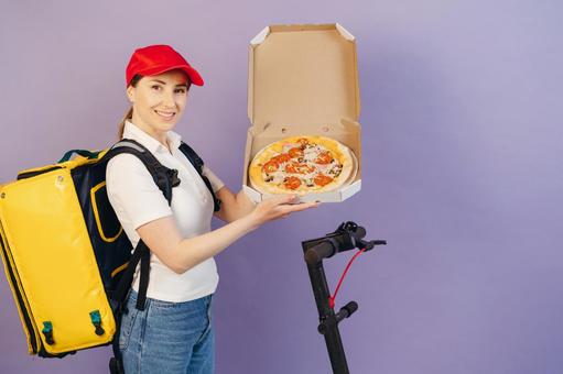 ピザ箱を開けて見せるフードデリバリーの女性 配達,フードデリバリー,デリバリーの写真素材