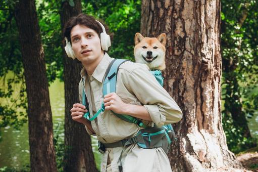 森の中で犬を背負う女性 男性,外国人,犬の写真素材