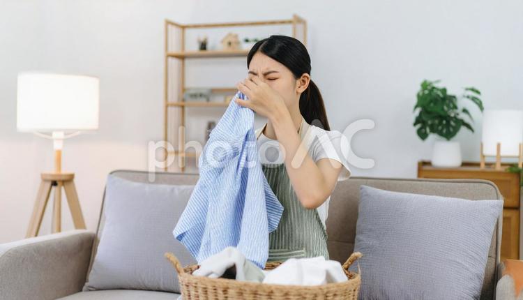 洗濯ものの生乾きの臭いに悩む女性 室内干し,部屋干し,悪臭の写真素材