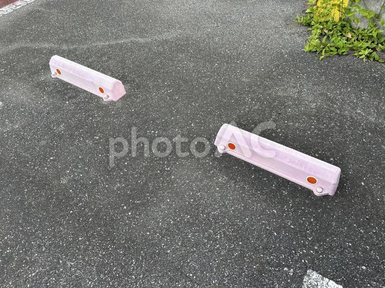 自動車のタイヤを止めるタイヤ止め 駐車場,parking,アスファルトの写真素材