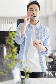 歯磨きをしながらスマホを見る男性 歯磨きをしながらスマホを見る男性 ビジネスマン,男性,歯磨きの写真素材