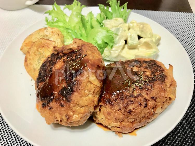 お皿に盛り付けられたハンバーグと付け合わせ お皿,サラダ,ハンバーグの写真素材