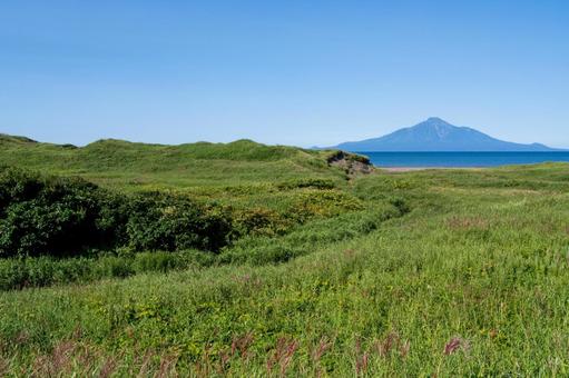 日本海越しに望む利尻岳の雄大な姿 日本海越しに望む利尻岳の雄大な姿 利尻岳,青空,草原の写真素材
