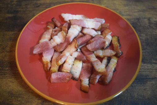 赤い皿に盛られたカリカリベーコン ベーコン,豚肉,肉の写真素材