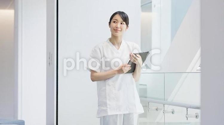 笑顔でタブレットを操作する看護師	 女性,看護師,病院の写真素材