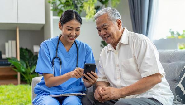 職員にスマホの操作を教わるシニア男性 職員にスマホの操作を教わるシニア男性の写真