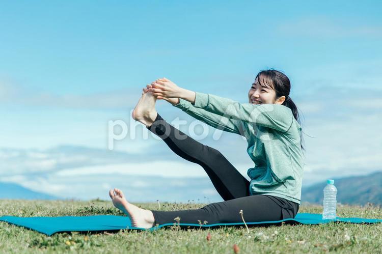 屋外でヨガをする女性 ストレッチ,脚上げ,ヨガの写真素材