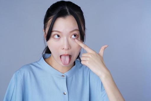 青い服の女性が舌を出す 女性,舌を出す,べーの写真素材