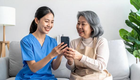 見守り訪問 スマホを使う高齢者とスタッフ 見守り訪問 スマホを使う高齢者とスタッフの写真