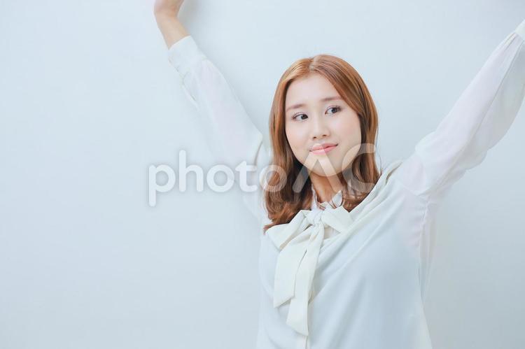 体操をする白いブラウス姿の若い女性 女性,ストレッチ,運動の写真素材