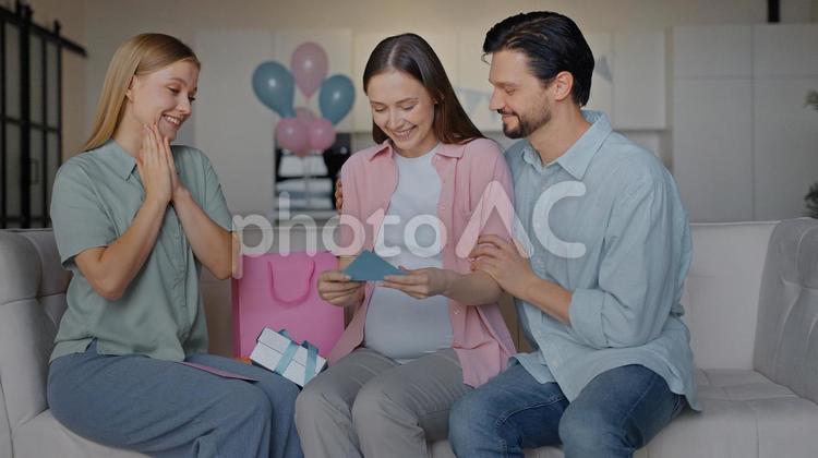 嬉しそうにメッセージカードを見る妊婦 女性,男性,人物の写真素材