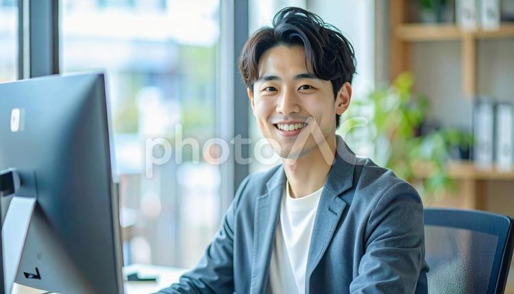 オフィスでパソコン操作をする男性 男性,パソコン,笑顔の写真素材
