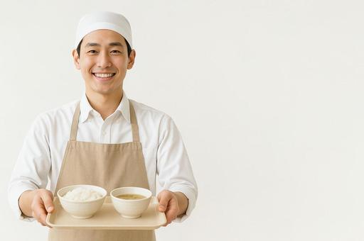 調理師が笑顔で給食トレーを両手で差し出す 調理師が笑顔で給食トレーを両手で差し出すの写真