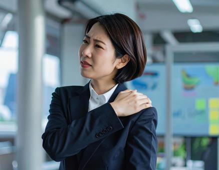 辛い肩凝りで苦しむ女性 辛い肩凝りで苦しむ女性の写真