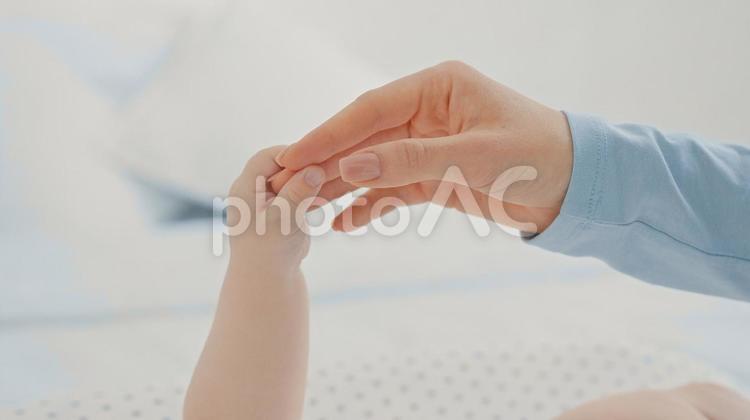 大人の手に触れる赤ちゃんの手 指,掴む,握るの写真素材