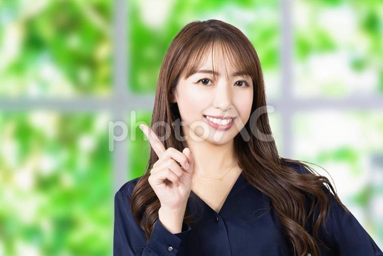 人差し指を立てて案内する女性 女性,ビジネス,笑顔の写真素材